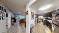 Located in Margate, Florida, this well-appointed single-floor, one-bedroom, one-bathroom home offers an efficient and thoughtfully designed layout. Wood-look flooring flows seamlessly throughout all living areas, creating a cohesive and clean aesthetic.

The kitchen is a standout feature, equipped with dark espresso cabinetry, stainless steel appliances including a range, dishwasher, and microwave, as well as light countertops and a pass-through breakfast bar that connects to the main living area. A window above the sink allows for natural light to brighten the space.

The open living room is generously proportioned and anchored by a large sliding glass door that provides direct views of the lush green outdoor area, filling the room with natural light. Recessed lighting adds to the bright, welcoming atmosphere.

The bedroom is a comfortable retreat with a closet, overhead lighting, and a neutral color palette that promotes a calm environment. It provides easy access to the full bathroom, which features a combined tub and shower, a single-sink vanity with dark cabinetry, and a mirrored medicine cabinet.

Neutral gray walls and textured ceilings are consistent throughout the home, contributing to a clean, modern feel well-suited for comfortable everyday living.