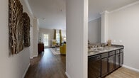 Located at Heron Pointe in Nashville, TN, this well-appointed three-bedroom, three-bathroom single-floor residence offers a thoughtfully designed layout across a comfortable footprint. The open-concept living area immediately draws attention with rich hardwood-style flooring, elegant crown molding, and natural light streaming through large windows. The living room provides ample space for relaxing and entertaining, flowing seamlessly into the dining area and kitchen. The kitchen features dark cabinetry, granite countertops, a double sink, and a breakfast bar with seating — ideal for casual dining. A dedicated dining space with hardwood-style flooring sits adjacent, completing the communal zone. The three bedrooms are carpeted and generously sized, including a spacious primary bedroom with a walk-in closet and direct bathroom access. Each bedroom benefits from natural light and a calm, neutral palette. The three bathrooms are finished with tile flooring, granite-topped vanities, and shower-tub combinations. A hallway connects the private quarters to the main living spaces, and an in-unit laundry area adds everyday convenience. Throughout, neutral tones and consistent finishes create a cohesive, welcoming ambiance.