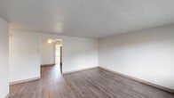 Located at 3105 Gateway St in Springfield, Oregon, this single-floor unit offers a clean, updated interior with a cohesive design throughout. Wood-style plank flooring runs consistently across the living areas, bedrooms, and kitchen, lending warmth and a sense of continuity to the space.

The living area is open and well-proportioned, featuring neutral white walls, textured ceilings, and a ceiling fan. A doorway connects to an adjacent area, enhancing the flow of the floor plan. Natural light filters in through windows fitted with horizontal blinds, offering views of the surrounding neighborhood.

The kitchen is thoughtfully appointed with white shaker-style cabinetry, dark countertops, and a full suite of stainless steel appliances including a refrigerator, range, and dishwasher. A stainless steel sink with a modern faucet completes the functional layout.

The bedrooms are comfortably sized with neutral walls and continued wood-style flooring. One bedroom features a mirrored sliding closet door, while windows in each room bring in natural light and outdoor views.

The bathroom is finished in a clean, white palette with a single-sink vanity, framed mirror, and a tub-shower combination, maintaining the updated aesthetic found throughout the unit.