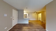 Located at 255 N Oakhurst Dr in Aurora, Illinois, this single-floor unit offers a practical and well-appointed layout designed for comfortable everyday living. The open-concept living and dining area greets residents upon entry, featuring warm wood-look plank flooring that extends throughout the main living spaces. Neutral gray and tan wall tones create a cohesive, move-in-ready aesthetic. A ceiling fan overhead adds both function and comfort to the living area.

The kitchen is efficiently designed with a galley-style layout, showcasing white cabinetry with modern hardware, granite-look countertops, a white subway tile backsplash, and a full suite of stainless steel appliances including a refrigerator, electric range, and over-the-range microwave. A convenient pass-through counter connects the kitchen to the main living space.

The bedrooms are carpeted for comfort and each include ceiling fans and ample natural light from windows with blinds. One bedroom features access to a walk-in closet area, providing useful storage.

The bathroom is well-finished with a granite-top vanity, framed mirror, stone-look tile flooring, and a full tub-shower combination with a curved curtain rod, complemented by brushed nickel fixtures and hardware throughout.