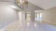 Located at 13401 North 50th Street in Tampa, FL, this two-story, 3-bedroom, 5-bathroom home offers a well-designed layout across two floors. The main floor impresses with dramatic vaulted ceilings that create a striking sense of openness and volume in the combined living, dining, and kitchen area. Large format light-toned tile flooring runs throughout the main living spaces, enhancing the bright, airy ambiance. The kitchen features white cabinetry, granite countertops with a breakfast bar, stainless steel appliances, and a subway tile backsplash. Sliding glass doors lead from the living room to a private balcony, bringing in natural light and outdoor views. The upper floor houses the bedrooms, including a generously sized primary bedroom with light wood-style flooring, a ceiling fan, and a dedicated en-suite bathroom complete with a walk-in marble-surround shower. Additional bedrooms feature carpet flooring, ceiling fans, and windows with natural light. Five bathrooms in total serve the home, including tub-shower combinations in secondary baths. With five closets distributed throughout and two hallways connecting the layout, this home delivers both practicality and comfort in a functional Tampa residence.