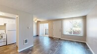 Located in the Woodstock neighborhood of Portland, Oregon, this two-bedroom, one-bathroom unit offers a practical and compact single-floor layout. The living room serves as the welcoming centerpiece of the home, featuring durable dark wood-style vinyl plank flooring, neutral beige walls, and a textured ceiling. A large window fitted with vertical blinds allows natural light to fill the space, creating a bright and open atmosphere.

The two bedrooms are carpeted in a warm neutral tone and share a consistent design aesthetic, each featuring baseboard heating and windows that invite natural light. The primary bedroom offers a sliding-door closet for ample storage, while the second bedroom also includes a closet, providing practical organization solutions. Both rooms feature the same textured ceiling found throughout the unit.

The full bathroom is clean and functional, equipped with a tiled shower-tub combo, a toilet, and a vanity with a granite-style countertop. Neutral wall tones keep the space feeling cohesive and understated.

The unit's efficient layout, visible in the 3D dollhouse view, places the kitchen and bathroom centrally, with bedrooms on one side and the living area near the entry. The overall design is simple and well-maintained, offering a comfortable living environment in a convenient Portland location.
