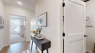Located at 1130 Hazeltine Boulevard in Chaska, MN, this thoughtfully designed single-floor home offers three bedrooms and two bathrooms across a generous, open layout. The welcoming entryway features light hardwood-style flooring and clean white walls, setting a modern tone throughout.

The open-concept kitchen is a standout, showcasing rich dark wood cabinetry, stainless steel appliances, and a white quartz-topped island with bar seating — ideal for both cooking and casual dining. Adjacent, the dining area is bathed in natural light from large windows with sheer curtains, offering pleasant outdoor views. The living room is equally bright and spacious, with hardwood-style flooring and large windows creating an airy, comfortable atmosphere.

The generously sized primary bedroom provides a quiet retreat, while the additional bedrooms offer versatile space with plush carpeting and ample natural light. The two bathrooms are clean and modern — one featuring a walk-in shower with wood-look flooring and dark vanity cabinetry, and the other a full tub-shower combo with a white quartz countertop vanity. A dedicated laundry room with side-by-side full-size washer and dryer adds everyday convenience. Ceiling fans in the bedrooms and consistent modern finishes throughout complete this well-rounded home.