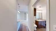 Located at 18545 University Blvd in Sugar Land, TX, this well-appointed 2-bedroom, 2-bathroom single-floor residence offers a functional and comfortable layout across a thoughtfully designed floor plan. The entrance leads into an open-concept living and dining area finished with plush carpet and neutral tones, filling the space with a bright, airy ambiance. Large windows allow generous natural light throughout, and a private balcony off the living area provides outdoor views of the surrounding community.

The kitchen is a standout feature, equipped with rich dark-wood cabinetry, granite countertops, stainless steel appliances including a refrigerator, range, and microwave, and a peninsula with pendant lighting and an integrated sink — ideal for both everyday cooking and entertaining.

Both bathrooms are well-finished with dark-wood vanities, granite countertops, framed mirrors, and warm overhead lighting. The primary bedroom offers a comfortable, carpeted retreat with a ceiling fan and a large window, accompanied by a spacious walk-in closet with built-in shelving and hanging rods. A dedicated laundry room with side-by-side washer and dryer and additional shelving adds everyday convenience. Hardwood-style flooring runs through the kitchen and hallways, complementing the overall warm, cohesive design throughout.