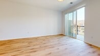 This impressive 3,170 square foot unit, located in Hartland, WI, offers a unique living experience spread across two floors. The main level, spanning 2,350 square feet, features an open-concept design that seamlessly integrates the kitchen and living areas. The kitchen is a highlight, boasting crisp white cabinetry, stainless steel appliances, and a practical layout perfect for cooking enthusiasts.

The unit's single bedroom, measuring 180 square feet, is situated on the upper floor, which encompasses 810 square feet. This level likely includes additional living space or potential for customization. Throughout the home, warm wood flooring adds a touch of elegance and continuity.

The bathroom is well-appointed with modern fixtures, including a glass-enclosed shower and built-in storage. Large windows and sliding glass doors leading to a balcony ensure ample natural light and offer outdoor views, enhancing the sense of spaciousness.

Notable features include ceiling fans for improved air circulation, barn-style sliding doors for a contemporary touch, and multiple entrances for convenience. The property's design emphasizes clean lines, neutral colors, and a minimalist aesthetic, creating a canvas for personal style while maintaining a modern, sophisticated ambiance.