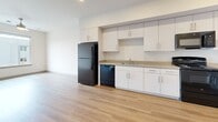 Located at 6819 N 27th Ave in Phoenix, Arizona, this one-bedroom, one-bathroom unit offers a thoughtfully designed single-floor layout ideal for comfortable everyday living. Light wood laminate flooring runs continuously throughout the space, creating a cohesive and easy-to-maintain interior. The open living area is bright and airy, featuring a ceiling fan with a light fixture and clean white walls that enhance the sense of openness.

The kitchen is efficiently laid out along a single wall, featuring white cabinetry with modern hardware, a full suite of black appliances including a refrigerator, dishwasher, and range, as well as recessed lighting overhead. The setup offers ample storage and counter space for daily meal preparation.

The bedroom is a comfortable, well-proportioned room equipped with its own ceiling fan and a window that allows natural light to fill the space, offering views of the surrounding Phoenix neighborhood, including mature palm trees. A closet provides convenient storage within the room.

The bathroom includes a wide vanity with white cabinetry and a large mirror, providing generous storage and counter space. A shower/tub combination with accessibility grab bars and tile surround completes the space. The unit also includes a dedicated entry area with a closet, adding practical functionality to this well-designed Phoenix residence.