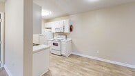 Located in Covington, Georgia, this single-floor, two-bedroom, two-bathroom home offers a practical and well-organized layout with a clean, neutral aesthetic throughout. The galley-style kitchen is a functional highlight, featuring crisp white cabinetry, marble-style countertops, light wood-look flooring, and a full suite of white appliances including a refrigerator, electric range, and built-in microwave — providing ample storage and counter space in a compact, efficient arrangement. Both bedrooms are carpeted and finished with warm beige tones, textured ceilings, and windows fitted with blinds that allow natural light to filter in. The spacious primary bedroom includes a mirrored closet and direct access to its own en-suite bathroom, while the second bedroom features a built-in closet and a nearby full bath. Each bathroom is appointed with white vanity cabinetry, marble-style countertops, a single sink, and a tub-shower combination. A connecting hallway ties the rooms together seamlessly. The consistent use of light, neutral tones and clean finishes throughout gives the home a bright, cohesive feel that is move-in ready.