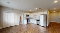 This single-floor residence in Colorado Springs, Colorado offers a thoughtfully designed layout with modern finishes throughout. The kitchen serves as a functional centerpiece, featuring white shaker-style cabinetry, granite countertops, a tile backsplash, and a full suite of stainless steel appliances including a range, over-the-range microwave, dishwasher, and refrigerator. Wood-style plank flooring runs throughout the main living areas, adding warmth and continuity to the space.

The open living area adjoins the kitchen, providing a generous, versatile space filled with recessed lighting. A sliding glass door leads to an outdoor area, while an additional window invites natural light, and a closet provides convenient built-in storage.

The bedroom is finished with plush carpeting, neutral-toned walls, and multiple windows fitted with blinds, allowing for ample natural light and a calm atmosphere. A ceiling fan adds comfort year-round.

The bathroom is well-appointed with a full soaking tub and shower combination, surrounded by large-format tile surround, wood-style flooring, and built-in shelving for added storage convenience. Clean, neutral tones carry throughout, creating a cohesive and contemporary feel across the entire space.