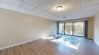 Located at 201 634 S National Ave in Springfield, Missouri, this single-floor unit offers two bedrooms and three bathrooms within a well-organized and functional layout. The interior is finished with warm wood-look flooring throughout, complemented by neutral beige walls and drop tile ceilings that lend a clean, uniform appearance to each room.

The generously sized primary bedroom stands out with dual windows that invite natural light from multiple directions, creating a bright and comfortable atmosphere. A secondary bedroom also features a window with blinds and includes a built-in closet with classic bi-fold doors, offering practical storage. Both rooms benefit from the same consistent flooring and warm wall tones.

The three bathrooms are thoughtfully appointed. One features a dark wood vanity with brushed nickel hardware, a white marble-style countertop, and wood-look flooring. Another includes a stand-up shower with chrome framing, a matching dark wood vanity, and toilet. A third bathroom showcases a soaking tub surrounded by crisp white subway tile, adding a refined touch.

A notable feature of the living area is the full-width sliding glass door that opens to an outdoor patio space, filling the room with natural light. The dedicated entrance provides a clear transition into the unit, rounding out this well-maintained and move-in-ready space.