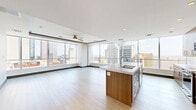 Located in the heart of Dallas, TX, this 2-bedroom, 4-bathroom residence offers a sophisticated urban living experience across a single thoughtfully designed floor. The open-concept kitchen and living area anchors the space, showcasing warm wood cabinetry, sleek stainless steel appliances, and a striking oversized waterfall-edge island with a marble-inspired quartz countertop — a true centerpiece for both cooking and entertaining. Light hardwood flooring flows throughout the main living areas, enhancing the bright, airy atmosphere.

The living room is defined by expansive floor-to-ceiling windows that frame sweeping panoramic views of the Dallas skyline, filling the space with abundant natural light. Both bedrooms are generously proportioned, carpeted for comfort, and feature large windows overlooking the city, along with ceiling fans for added convenience. The spacious primary bedroom is complemented by a well-appointed en-suite bathroom featuring marble-style tile, a deep soaking tub, glass-enclosed shower, and a dual-sink vanity with warm wood cabinetry and gold hardware accents. Two walk-in closets with built-in shelving and hanging rods provide ample storage throughout the residence.