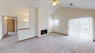 Located at 4014 W Hollow Creek Dr in Peoria, Illinois, this single-floor home offers a well-designed layout with a blend of comfort and functionality. The expansive living room is a standout feature, boasting dramatic vaulted ceilings, a ceiling fan, a tiled fireplace, and access to an outdoor area through a sliding glass door with vertical blinds. Natural light filters in through a window, enhancing the bright, open atmosphere. Plush wall-to-wall carpeting runs throughout the living areas and bedrooms.

The kitchen is open to the living area via a pass-through counter, creating an airy, connected feel. It is equipped with warm honey-toned oak cabinetry, a full suite of white appliances including a refrigerator, electric range, over-the-range microwave, and dishwasher, all set on hardwood flooring with light laminate countertops.

The bedrooms are generously sized, each featuring carpeted floors, ceiling fans, and natural light from windows. Closets with built-in shelving provide ample storage. Two full bathrooms serve the home, each featuring oak vanity cabinetry and a tub/shower combination, with wood-look tile flooring adding a clean, cohesive finish throughout.
