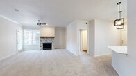 This single-story, 3-bedroom, 2-bathroom home offers a thoughtfully designed layout that balances comfort and functionality. The living room serves as the heart of the home, showcasing a standout herringbone-tiled fireplace with a rustic wood mantel, soft carpeting underfoot, a ceiling fan, and large windows that invite natural light throughout the space.

The kitchen is a modern and functional standout, featuring crisp white shaker cabinetry, a classic subway tile backsplash, stainless steel appliances, and a spacious white quartz peninsula with a double-basin sink and a high-arc faucet. Industrial-style pendant lighting and a skylight add to the kitchen's bright, contemporary character, while wood-look flooring grounds the space.

The generously sized primary bedroom includes a ceiling fan and built-in shelving, offering practical storage solutions alongside comfortable living. Additional bedrooms are carpeted, each equipped with ceiling fans, and one features large windows and a glass-paned door providing outdoor views. Two closets and a dedicated laundry area add to the home's functional appeal.

The bathrooms are clean and classic in design, with one featuring a full tub-shower combination with tile surround, white cabinetry with overhead storage, and wood-look flooring. Overall, the home presents a bright, neutral palette throughout.