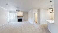 This single-story, 3-bedroom, 2-bathroom home offers a thoughtfully designed layout that balances comfort and functionality. The living room serves as the heart of the home, showcasing a standout herringbone-tiled fireplace with a rustic wood mantel, soft carpeting underfoot, a ceiling fan, and large windows that invite natural light throughout the space.

The kitchen is a modern and functional standout, featuring crisp white shaker cabinetry, a classic subway tile backsplash, stainless steel appliances, and a spacious white quartz peninsula with a double-basin sink and a high-arc faucet. Industrial-style pendant lighting and a skylight add to the kitchen's bright, contemporary character, while wood-look flooring grounds the space.

The generously sized primary bedroom includes a ceiling fan and built-in shelving, offering practical storage solutions alongside comfortable living. Additional bedrooms are carpeted, each equipped with ceiling fans, and one features large windows and a glass-paned door providing outdoor views. Two closets and a dedicated laundry area add to the home's functional appeal.

The bathrooms are clean and classic in design, with one featuring a full tub-shower combination with tile surround, white cabinetry with overhead storage, and wood-look flooring. Overall, the home presents a bright, neutral palette throughout.