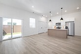 Located at 4107 Laster Ln in Caldwell, Idaho, this well-designed single-story home offers three bedrooms, three bathrooms, and a thoughtful layout that maximizes functionality and comfort. Light wood-look flooring flows consistently throughout, creating a bright and cohesive aesthetic across every room.

The open-concept kitchen is a standout feature, showcasing crisp white shaker cabinetry, a generous center island with a white quartz countertop and undermount sink, stainless steel appliances including a refrigerator, electric range, and over-the-range microwave, and striking black pendant lighting with gold interiors. The adjacent living room benefits from recessed lighting, a ceiling fan, multiple windows with white blinds, and sliding glass doors that open directly to a private, fenced backyard with a patio and lawn area.

The bedrooms are finished in the same neutral palette, featuring light walls, wood-look flooring, and windows that allow ample natural light. The primary bedroom includes a walk-in closet with built-in shelving. The bathrooms are clean and modern, outfitted with white cabinetry, quartz countertops, and gold and matte black fixtures. One bathroom features a full tub-shower combination. The home's consistent use of light tones and quality finishes gives it a fresh, move-in-ready appeal.