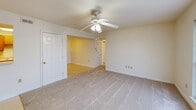 Located at 1901 Lipscomb Rd E in Wilson, NC, this 2-bedroom, 1-bathroom unit delivers a practical and comfortable single-floor layout. The combined kitchen and living room forms the heart of the home, with the living area featuring soft carpeting, a ceiling fan with light fixture, and a window that lets in natural light. A pass-through opening connects the living area to the kitchen, which is equipped with warm wood-toned cabinetry, ample counter space, a double-basin stainless steel sink, and white appliances including a refrigerator, dishwasher, and electric range. Light vinyl flooring completes the kitchen. A connecting hallway leads to both bedrooms and the bathroom. Each bedroom is finished with plush carpet and ceiling fans with lighting; the primary bedroom includes a spacious double-door closet, while the secondary bedroom benefits from a large window with views of surrounding greenery. The full bathroom features a tub/shower combination, toilet, and sink, all finished in clean white tones with tile flooring. Throughout the unit, neutral walls, white panel doors with brass hardware, and consistent finishes create a cohesive and move-in-ready feel.