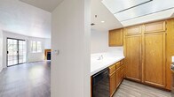 Located in the heart of Los Angeles on Franklin Ave, this one-bedroom, one-bathroom unit offers a well-planned layout across a single floor. The open living room is a standout, featuring sleek hardwood-style flooring, crisp white walls, and a wood-trimmed fireplace that serves as a natural focal point. Large sliding glass doors and adjacent windows flood the space with natural light and provide direct access to a private patio with greenery views, creating a bright and airy atmosphere. The kitchen is thoughtfully designed with warm oak cabinetry, ample storage, white countertops, a skylight overhead, and black appliances including a dishwasher, gas range, and refrigerator. A pass-through opening connects the kitchen to the living area, enhancing the sense of openness. The bedroom is a comfortable retreat with plush wall-to-wall carpeting, a window with natural light, and access to a dedicated closet for storage. The full bathroom features wood-style tile flooring, a wide vanity with a large mirror, generous under-sink cabinetry, and a shower-tub combo with clean white tile surround. The overall aesthetic is clean, neutral, and move-in ready.