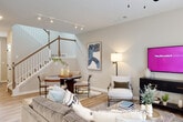 This two-story residence offers a thoughtfully designed layout that balances comfort and functionality across both floors. The main level centers around an open-concept living area finished with wood-look flooring, a ceiling fan, and large double doors framed by floor-to-ceiling drapes that invite natural light and provide outdoor views. The space flows seamlessly into a dining area and a well-equipped kitchen featuring white shaker cabinetry with matte black hardware, granite countertops, stainless steel appliances including a gas range and French door refrigerator, and a peninsula with an undermount sink topped by a pendant light. A half bathroom on the main level adds convenience for guests, finished with matching wood-look flooring and clean white cabinetry. A staircase with a classic wood banister connects the levels, with a gallery-style hallway displaying framed artwork along the way. The upper floor hosts the bedrooms, each carpeted and appointed with ceiling fans and natural light from well-positioned windows. Bathrooms on this level include a walk-in glass shower, white vanity, and wood-look tile flooring. Neutral tones and consistent finishes throughout create a cohesive, welcoming ambiance.
