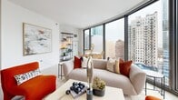 Located at 1001 South State Street in Chicago's South Loop neighborhood, this one-bedroom, one-bathroom residence offers a well-designed layout across a single floor. The entry hallway, flanked by louvered closet doors, leads into a bright, open-concept living, dining, and kitchen area bathed in natural light from expansive floor-to-ceiling windows that frame sweeping city skyline views. The living area features light hardwood-style flooring and a clean, contemporary aesthetic throughout. The kitchen is thoughtfully appointed with white cabinetry, a mosaic tile backsplash, light quartz countertops, and stainless steel appliances, including a gas range and refrigerator. The bedroom is generously proportioned, offering large windows with urban views, light wood flooring, and direct access to a dedicated walk-in closet with built-in shelving. The bathroom is finished with large-format tile flooring, a white vanity with under-mount sink, a mirrored medicine cabinet, and a glass-enclosed walk-in shower with tile surround. An in-unit laundry area adds everyday convenience. The residence strikes a balance between modern finishes and functional design, making it a polished urban retreat in the heart of Chicago.