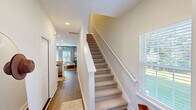 Located at 104 Lusk Ln in Pooler, Georgia, this two-story home offers three bedrooms, three bathrooms, and a well-organized layout across two floors. The main level hosts an open-concept living, dining, and kitchen area finished with wood-look flooring and soft sage-green accent walls. The kitchen is equipped with white shaker cabinetry, granite countertops, stainless steel appliances, and a central island with seating — flowing seamlessly into the dining area and living room, which is bright and inviting with natural light from large windows. A pantry and laundry room add practical convenience on this level. Carpeted stairs with a white rail banister lead to the upper floor, where the generously sized primary bedroom features vaulted ceilings, a ceiling fan, multiple windows, and a dedicated closet. The additional bedrooms are well-proportioned and share well-appointed bathrooms, each featuring granite vanity tops, white cabinetry, and tub-shower combinations. Six closets are distributed throughout the home, ensuring ample storage. Surrounded by mature trees, the property enjoys a naturally shaded setting while remaining close to the amenities of Pooler, GA.