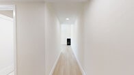 Located in the Palms neighborhood of Los Angeles, this thoughtfully designed 2-bedroom, 2-bathroom home delivers a clean, modern aesthetic throughout. Light oak hardwood flooring runs continuously across the single floor, tying together a bright and cohesive interior. The open-concept kitchen and living area serves as the heart of the home, highlighted by soaring vaulted ceilings with clerestory windows that flood the space with natural light. The kitchen features warm natural wood cabinetry, a textured white subway tile backsplash, stainless steel appliances including a gas range and refrigerator, and a striking peninsula with a waterfall-edge white quartz countertop. The living area offers a standout three-sided corner fireplace with a sleek black surround and sliding glass doors opening to a private outdoor terrace with open city views. Both bedrooms are well-proportioned and serene, featuring vaulted or angled ceilings, natural light from large windows, and modern frosted-glass sliding closet doors. The two bathrooms are finished with white subway tile, large-format floor tile, black-framed sliding glass shower enclosures, and clean white vanities, delivering a sharp, contemporary look throughout. Hallways connect the living spaces efficiently, completing a well-planned layout ideal for comfortable urban living.