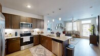 Located at 1450 Valley Ridge Blvd in Lewisville, TX, this single-floor, 2-bedroom, 3-bathroom residence offers a thoughtfully designed layout with modern finishes throughout. Light wood-style flooring flows through the main living areas, creating a warm and cohesive aesthetic.

The open-concept kitchen and living room serve as the heart of the home. The kitchen is outfitted with rich dark wood cabinetry, granite countertops, stainless steel appliances including a side-by-side refrigerator, electric range, and microwave, plus a functional island that transitions seamlessly into the living area. The living room features large windows with plantation shutters that invite abundant natural light, complemented by a ceiling fan overhead.

The primary bedroom is a comfortable retreat with a ceiling fan, plush carpet, and a window offering outdoor views. It includes dedicated closet space and is served by a well-appointed en-suite bathroom featuring a dual-sink vanity with granite countertops, dark wood cabinetry, and wood-style flooring. The second bedroom is versatile and bright, with carpet flooring, natural light from large windows, and space for both sleeping and a work area. Additional bathrooms feature granite vanities and tub-shower combinations, maintaining consistent design throughout.