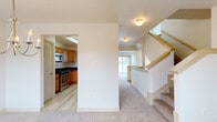 Located at 305 Country Ridge Dr in Red Lion, PA, this three-bedroom, three-bathroom home is thoughtfully arranged across three floors. The entry-level garage features an automatic opener and a dedicated laundry area equipped with a full-size washer and dryer. Light wood-style flooring runs through the main living areas, complemented by plush carpet in the bedrooms and living room. The main floor hosts an open-concept kitchen and living room, where warm honey-toned cabinetry, dark countertops, and stainless steel appliances — including a refrigerator and range — define the kitchen. The adjacent living area benefits from large windows that invite natural light and offer views of the surrounding neighborhood. A chandelier adds a refined touch to the dining nook. Each bedroom features carpeted floors, generous windows, and ample closet space, with the spacious primary bedroom offering room to comfortably accommodate large furnishings. The primary bathroom includes a double-sink vanity with rich wood cabinetry, a wide mirror, and a soaking tub with shower. Three staircases connect the floors, and hallways with louvered closet doors provide additional storage. The home offers a well-balanced combination of functional layout and comfortable living throughout all three levels.