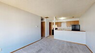Located at 404 E Maple St in Le Roy, Illinois, this one-bedroom, one-bathroom unit offers a practical and efficient single-floor layout. The open-concept living area features neutral gray walls, soft carpeted flooring, and a textured ceiling, creating a clean and functional space. A peninsula counter connects the living area to the kitchen, providing a natural divide while maintaining an open feel. The kitchen is equipped with warm oak cabinetry — both upper and lower — white laminate countertops, a stainless steel single-basin sink, a black refrigerator, and a range, all set on easy-to-maintain tile flooring. The bedroom offers a comfortable, carpeted retreat with a large window that allows natural light to fill the room and provides views of the surrounding neighborhood. A closet is accessible from the bedroom, adding practical storage. The bathroom features tile flooring, a wood-toned vanity with a white countertop, a full-size soaking tub with shower, and a wood-panel door — offering a straightforward and functional design. Throughout the unit, consistent finishes and a neutral color palette provide a cohesive, move-in-ready atmosphere suitable for everyday living.