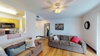 Located at 716 W Carolina St in Tallahassee, FL, this single-story home offers a practical and comfortable layout designed for everyday living. Warm hardwood flooring runs throughout the interior, creating a cohesive and inviting atmosphere across all rooms.

The living area is generously sized, featuring ceiling fans, neutral white walls, and vertical blinds that allow natural light to filter in. The space comfortably accommodates multiple seating arrangements and includes a wall-mounted television area, making it well-suited for both relaxing and entertaining.

The kitchen is equipped with black appliances, including a refrigerator, electric range, and over-range microwave. Honey-toned cabinetry pairs with light countertops, and the layout provides functional workspace. A dedicated laundry area with a full-size washer is conveniently located within the unit.

Multiple bedrooms offer comfortable personal spaces, each with ceiling fans, natural light from windows with blinds, and hardwood flooring. The rooms provide ample space for sleeping and studying.

The bathrooms include a vanity with wood cabinetry and a mirror with overhead lighting, as well as a separate shower stall. The overall design is straightforward and functional, making this home a practical choice in the Tallahassee area.