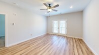 This well-appointed three-bedroom, two-bathroom residence in Burlington, NC offers a thoughtfully designed single-floor layout that maximizes comfort and functionality. The open-concept kitchen and living area serves as the heart of the home, featuring light hardwood-style flooring, recessed lighting, and French doors that invite natural light while providing access to an outdoor balcony. The kitchen is equipped with stainless steel appliances, including a range, microwave, refrigerator, and dishwasher, complemented by light cabinetry, a white countertop, and a peninsula that adds prep space and casual dining potential. The spacious living room includes a ceiling fan and seamlessly connects to the kitchen for easy entertaining. The generously sized primary bedroom features plush carpeting, a ceiling fan, a walk-in closet with wire shelving, and natural light from a window. Additional bedrooms are well-proportioned, with one offering hardwood-style flooring and another with carpet and a double-door closet. Both bathrooms are clean and functional, each featuring a tub-shower combination and wood-style flooring. A dedicated hallway and closet complete the practical layout of this move-in-ready home.