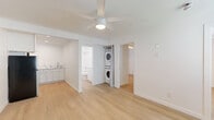 Located at 6343 Rosemead Boulevard in San Gabriel, CA, this efficiently designed 2-bedroom, 2-bathroom unit offers a clean, modern aesthetic throughout. Light wood-style flooring spans the entire space, complementing crisp white walls and creating a bright, cohesive atmosphere.

The open living and dining area serves as the heart of the unit, featuring a ceiling fan with integrated lighting. A wall-unit air conditioner and a bold dark front door add functional and visual contrast to the otherwise bright interior. Natural light filters in through a window fitted with blinds.

The kitchen is thoughtfully laid out with white shaker-style cabinetry, marble-look countertops, a stainless steel refrigerator, and a range, providing ample functionality within a compact footprint. A conveniently tucked stacked washer and dryer unit adds in-unit laundry access.

Both bedrooms are well-proportioned with light wood flooring, ceiling fans, and generous closet space — one bedroom features mirrored sliding closet doors. Each room benefits from a window unit for climate control.

The two bathrooms are finished in a clean, all-white palette, each offering a shower/tub combination with chrome fixtures, a toilet, and one bathroom includes a vanity with marble-look countertop. Three additional closets throughout the unit provide excellent storage capacity.