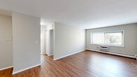Located at 40 Zabriskie St in Hackensack, NJ, this one-bedroom unit offers a well-organized single-floor layout with a practical and clean design throughout. Warm hardwood-style flooring flows consistently across every room, lending a cohesive and inviting feel to the entire space.

The open living area provides a generous, airy footprint, with neutral gray walls and clean white trim that create a bright, versatile backdrop. Natural light enters through windows fitted with horizontal blinds, and a wall-mounted air conditioning unit ensures year-round comfort. Baseboard heating runs along the perimeter, adding an efficient heating solution.

The kitchen is thoughtfully appointed with warm honey-toned wood cabinetry, dark granite-style countertops, and a mosaic tile backsplash that adds a decorative accent. A gas range and stainless steel sink are neatly integrated, while a window above the counter brings in natural light and a view of the surrounding neighborhood.

The bedroom is a comfortable, well-proportioned room featuring two windows that provide cross-ventilation and ample natural light, along with baseboard heating and a wall AC unit. The room is accessed through a classic six-panel white door.

Overall, the space presents a clean, move-in ready environment with functional amenities in a convenient Hackensack location.