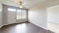 Located on Lake Superior Road in Valparaiso, Indiana, this well-designed two-bedroom, two-bathroom residence offers a thoughtful single-floor layout with a comfortable sense of space throughout. The kitchen is a standout feature, showcasing rich dark-toned cabinetry, granite countertops, and a full suite of stainless steel appliances including a gas range, built-in microwave, dishwasher, and a side-by-side refrigerator with an in-door water and ice dispenser. Dark hardwood-style flooring flows through the kitchen and into the open living area, which is brightened by a large window and accented by a ceiling fan overhead. The primary bedroom is generously sized, offering a spacious walk-in closet equipped with wire shelving and hanging rods for ample storage. The second bedroom features plush carpeting and a large window that lets in abundant natural light. Both bathrooms are finished with granite-top dark wood vanities; one includes a soaking tub with tiled surround, while the other features a glass-enclosed shower. Soft carpet in the bedrooms and closet provides a warm contrast to the hard flooring in the main living spaces, creating a cohesive and comfortable living environment.