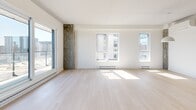 Located on the 8th floor at 2255 Boul Daniel Johnson in Laval, this well-appointed 2-bedroom, 2-bathroom unit offers a thoughtfully designed open-concept layout with contemporary finishes throughout. Light hardwood flooring runs seamlessly across the living areas, complementing the crisp white walls and creating a bright, airy ambiance. Exposed concrete structural columns add an industrial character that contrasts beautifully with the otherwise clean modern aesthetic.

The combined kitchen and living area serves as the heart of the unit. The kitchen features a large central island with an integrated sink, stainless steel appliances including a refrigerator and range, and two-toned cabinetry in white and natural wood. The generous living area is bathed in natural light through multiple large windows offering views of the surrounding Laval cityscape.

Both bedrooms are well-sized, featuring light hardwood floors, ample closet space, and windows that bring in natural light. The hallway is anchored by a sliding barn-style door and an exposed concrete column, reinforcing the unit's modern-industrial character.

The two bathrooms are finished with neutral-toned tiles. The primary bathroom includes a glass-enclosed walk-in shower, while the second bathroom features a soaking tub with a glass shower enclosure, both equipped with contemporary wood-paneled vanities and white countertops.
