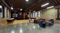 Located at 1352 N Wells St in Chicago's vibrant Old Town neighborhood, this single-floor space combines industrial architecture with an energetic, urban aesthetic. The design is anchored by exposed brick walls, original heavy timber columns and ceiling beams, and polished concrete floors that transition into warm hardwood in select zones, creating a dynamic contrast throughout.

The main gathering area is generously open, accommodating lounge seating with leather sofas and club chairs arranged around a low-profile coffee table. Bold, colorful graffiti-style murals cover the brick walls, adding a distinctly creative and artistic character to the space. A wall-mounted flat-screen television enhances the lounge area for viewing and entertainment.

A dedicated game zone features a regulation pool table and a shuffleboard table, complemented by bar-height seating and framed photography displayed against dark-painted accent walls. A vintage arcade cabinet adds a playful retro touch. A separate dining area with dark wood tables and upholstered chairs provides a more intimate setting.

The entrance lobby impresses with soaring ceilings, expansive floor-to-ceiling glazing that floods the space with natural light, exposed ductwork, and a reception desk framed by red steel accents and brick. The overall ambiance is lively, creative, and well-suited for private events, gatherings, or social activities.