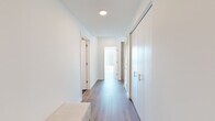 Located at 1000 S Michigan Ave in Chicago's vibrant South Loop neighborhood, this thoughtfully designed 2-bedroom, 2-bathroom residence offers a refined urban living experience. The open-concept kitchen and living area serves as the heart of the home, anchored by a sleek kitchen featuring light wood cabinetry, a marble-style backsplash, a waterfall-edge island with bar seating, and pendant lighting. Floor-to-ceiling windows in the living area flood the space with natural light and frame sweeping views of the Chicago skyline. Hardwood-style flooring flows throughout, complementing the clean, modern aesthetic. The primary bedroom is generously proportioned, offering a serene retreat with ample closet space. A dedicated custom closet with wood shelving, built-in drawers, and hanging rods provides exceptional storage. The two bathrooms showcase distinct, high-end finishes — one features dramatic marble-style flooring and wall tiles with a glass-enclosed shower, while the second offers a wood-accented vanity with a white quartz countertop and a sleek walk-in shower. A bright, well-appointed hallway connects the private quarters, completing this polished and functional urban residence.
