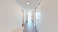 Located at 1000 S Michigan Ave in Chicago's vibrant South Loop neighborhood, this thoughtfully designed 2-bedroom, 2-bathroom residence offers a refined urban living experience. The open-concept kitchen and living area serves as the heart of the home, anchored by a sleek kitchen featuring light wood cabinetry, a marble-style backsplash, a waterfall-edge island with bar seating, and pendant lighting. Floor-to-ceiling windows in the living area flood the space with natural light and frame sweeping views of the Chicago skyline. Hardwood-style flooring flows throughout, complementing the clean, modern aesthetic. The primary bedroom is generously proportioned, offering a serene retreat with ample closet space. A dedicated custom closet with wood shelving, built-in drawers, and hanging rods provides exceptional storage. The two bathrooms showcase distinct, high-end finishes — one features dramatic marble-style flooring and wall tiles with a glass-enclosed shower, while the second offers a wood-accented vanity with a white quartz countertop and a sleek walk-in shower. A bright, well-appointed hallway connects the private quarters, completing this polished and functional urban residence.