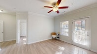 This one-bedroom, one-bathroom residence at 338 Walden Creek Way in Greenville, SC offers a thoughtfully designed single-floor layout. Light hardwood-style flooring runs throughout, creating a clean and cohesive look across all rooms. The living room is bright and inviting, featuring crown molding, a ceiling fan with light fixture, and access to a private balcony through a glass-paned door — allowing natural light to pour in and providing outdoor views of the surrounding greenery. The kitchen is efficiently laid out with warm honey-toned cabinetry, light countertops, and black appliances including a range, refrigerator, and dishwasher. The bedroom is a comfortable, sun-filled retreat with a large window offering natural light and direct access to generous closet space — one of four closets found throughout the home. The bathroom features a wood-toned vanity with a single sink, a large mirror with overhead lighting, and a shower-tub combination. A dedicated utility room adds practical convenience. With neutral wall tones, ample storage, and a functional flow between spaces, this residence offers a comfortable and well-organized living environment in Greenville's desirable 29615 area.