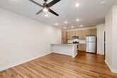 Located at 4660 Derrick Rd in Union City, GA, this 1-bedroom, 1-bathroom unit offers a thoughtfully designed layout with modern finishes across a single floor. The open-concept living area seamlessly integrates the living room, dining space, and kitchen, creating a bright and functional environment. Recessed lighting and ceiling fans are present throughout, enhancing both comfort and ambiance.

The kitchen is a standout feature, equipped with stainless steel appliances including a refrigerator, range, and microwave. Light wood-tone cabinetry reaches toward the ceiling for ample storage, while a peninsula with a granite-style countertop and built-in sink provides additional prep space and casual seating. A white tile backsplash adds a clean, contemporary touch.

Warm wood-look flooring runs throughout the unit, adding continuity and a welcoming feel. The bedroom is generously sized, bathed in natural light from multiple windows with outdoor views of surrounding greenery, and includes a ceiling fan and a double-door closet. An additional closet provides further storage flexibility.

The bathroom features a granite-top vanity, light wood cabinetry, and a full soaking tub with tiled surround and built-in shelving. The unit also includes a dedicated laundry area and utility room, completing a practical and well-rounded floor plan.