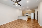 Located at 4660 Derrick Rd in Union City, GA, this 1-bedroom, 1-bathroom unit offers a thoughtfully designed layout with modern finishes across a single floor. The open-concept living area seamlessly integrates the living room, dining space, and kitchen, creating a bright and functional environment. Recessed lighting and ceiling fans are present throughout, enhancing both comfort and ambiance.

The kitchen is a standout feature, equipped with stainless steel appliances including a refrigerator, range, and microwave. Light wood-tone cabinetry reaches toward the ceiling for ample storage, while a peninsula with a granite-style countertop and built-in sink provides additional prep space and casual seating. A white tile backsplash adds a clean, contemporary touch.

Warm wood-look flooring runs throughout the unit, adding continuity and a welcoming feel. The bedroom is generously sized, bathed in natural light from multiple windows with outdoor views of surrounding greenery, and includes a ceiling fan and a double-door closet. An additional closet provides further storage flexibility.

The bathroom features a granite-top vanity, light wood cabinetry, and a full soaking tub with tiled surround and built-in shelving. The unit also includes a dedicated laundry area and utility room, completing a practical and well-rounded floor plan.