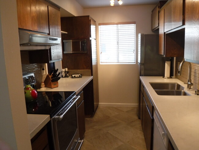 Kitchen features electric stove, microwave, dishwasher, refrigerator - 1046 Miramonte Dr