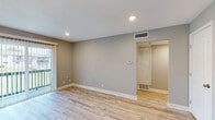 Located at 6037 Barton Dr in Shawnee, Kansas, this single-floor residence offers a clean, updated interior with a cohesive neutral color palette throughout. Light wood-look luxury vinyl plank flooring runs continuously across the entire space, lending a bright and cohesive feel to every room.

The living area is spacious and well-lit, featuring recessed lighting, a wall-mounted thermostat, and a sliding glass door dressed with vertical blinds that opens to an outdoor balcony with views of the surrounding neighborhood. An adjacent entry area provides two interior doors, offering convenient access to additional spaces.

The kitchen is thoughtfully appointed with gray shaker-style cabinetry, white countertops, a white subway tile backsplash, and a full suite of stainless steel appliances including a gas range, built-in microwave, dishwasher, and refrigerator. A window above the sink allows natural light to fill the space.

The bedrooms are generously sized, each featuring ceiling fans with light fixtures and windows fitted with white blinds that provide natural light and privacy. Closet storage is also present throughout.

The bathroom is neatly finished with a gray vanity, white countertop, globe vanity lighting, a mirror, and light-toned tile flooring, completing this well-maintained and move-in-ready home.