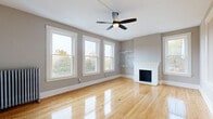 Located at 65 S Pleasant St in the heart of Amherst, MA, this well-appointed 3-bedroom, 2-bathroom home offers a thoughtfully designed single-floor layout. Gleaming hardwood floors run throughout, tying together a cohesive and warm aesthetic.

The living room is a standout space, anchored by a classic white-mantled fireplace with a brick hearth, flanked by built-in shelving and bathed in natural light from a trio of large double-hung windows. A ceiling fan adds comfort and character to the airy room.

The kitchen is stylishly updated with slate-blue cabinetry, a herringbone marble tile backsplash, stainless steel appliances including a dishwasher and refrigerator, and rich hardwood floors. A decorative ceiling tile adds vintage charm, and a dedicated pantry with built-in shelving offers excellent storage.

The three bedrooms feature hardwood floors, ceiling fans, and ample natural light from generously sized windows. One bedroom includes a radiator heater, lending a nod to the home's classic character.

Both bathrooms are finished with crisp black-and-white mosaic tile floors and white walls. One bathroom features dual pedestal sinks with matte black fixtures, while the other includes a sleek glass-enclosed marble-tiled shower. Two closets and a hallway complete this well-organized home.