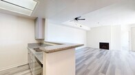 This contemporary apartment, located at 1335 N La Brea Ave in Los Angeles, offers 850 square feet of thoughtfully designed living space. The single-story layout encompasses two bedrooms and two bathrooms, with the primary bedroom boasting a generous 160 square feet. The heart of the home is an open-concept kitchen and living room, creating a seamless flow for entertaining and daily life.

Throughout the apartment, light-toned wood-look flooring adds warmth and continuity. The kitchen features sleek white cabinetry, stainless steel appliances, and granite countertops, offering both style and functionality. A breakfast bar provides additional seating and separates the kitchen from the living area.

The living room is highlighted by a fireplace and sliding glass doors leading to an outdoor space, allowing natural light to flood the interior. Both bedrooms offer ample space and closet storage. The bathrooms are outfitted with modern fixtures, including glass-enclosed showers and vanities with granite countertops.

Additional amenities include a ceiling fan for improved air circulation and vertical blinds for privacy. The neutral color palette and clean lines create a fresh, contemporary ambiance throughout the space, making it an ideal urban retreat in the heart of Los Angeles.