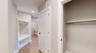 This thoughtfully designed 2-bedroom, 2-bathroom residence in Chapel Hill, NC offers a clean, contemporary aesthetic throughout. Light-toned hardwood floors flow seamlessly across the entire single-floor layout, tying each space together with warmth and cohesion. The living room is a standout, featuring floor-to-ceiling glass doors that open to a private balcony with sweeping outdoor views, flooding the interior with abundant natural light. The well-equipped kitchen impresses with tall white shaker cabinetry, dark hardware accents, a glass-top cooktop, stainless steel refrigerator, a dedicated wine rack, and generous counter space — all finished with a crisp white palette. The primary bedroom is spacious, offering serene natural light and access to a luxurious en-suite bath complete with a glass-enclosed walk-in shower, a soaking tub clad in neutral stone-look tile, dual vanity, and a walk-in closet. The second bedroom is bright and well-proportioned, served by a second full bathroom featuring a tub-shower combination with matching tile surround. A dedicated laundry room with a full-size washer and dryer, built-in shelving, and additional closet storage add everyday convenience. Neutral tones and recessed lighting throughout create a polished, move-in-ready atmosphere.