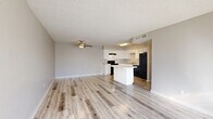 Located at 2350 E Water St in Tucson, AZ, this 2-bedroom, 2-bathroom single-floor unit offers a well-organized layout with a comfortable, functional design throughout. The open-concept living and kitchen area serves as the heart of the home, featuring light wood-look flooring, a textured ceiling, and a ceiling fan that keeps the space airy. Large windows allow generous natural light to pour in, brightening the entire common area. The kitchen is outfitted with white cabinetry, granite-look countertops, black appliances including a range, dishwasher, and refrigerator, and a central island that provides additional prep and seating space. Both bedrooms are carpeted and showcase a distinctive painted white brick accent wall, adding character and texture to each room. The primary bedroom is generously sized, featuring an arched window, a ceiling fan, and access to a walk-in closet. The second bedroom also offers a ceiling fan and a large window with natural light. Each bathroom has a clean, modern finish — one featuring a tub/shower combo and the other a dedicated shower stall — both with light wood-look flooring. A dedicated laundry area and three closets round out the practical amenities of this well-appointed Tucson residence.