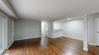Located at 45 Birch St in Kingston, NY, this single-floor, three-bedroom, one-bathroom residence offers a well-organized layout with a clean, neutral aesthetic throughout. Rich hardwood flooring flows consistently across every room, complementing the soft gray walls and crisp white trim that define the interior's modern yet approachable character.

The open-concept living and kitchen area serves as the heart of the home. The kitchen features gray cabinetry, a full-size refrigerator, and a sink, all framed by a defining peninsula with a warm butcher block countertop and built-in open shelving below — an ideal spot for casual dining or additional storage. The living area is generously proportioned and benefits from a sliding glass door that opens directly to a private balcony, filling the space with natural light and providing outdoor views.

Three well-sized bedrooms each continue the hardwood flooring and neutral palette, with windows that allow for ample natural light. The primary bedroom is notably spacious, offering room for a full furniture arrangement. One bedroom also features sliding door access to the balcony. A dedicated closet provides additional storage for the unit.

The bathroom includes a clean, full-size soaking tub and shower enclosure finished in white. A hallway connects the living spaces to the bedrooms, completing this efficiently designed, move-in-ready residence.