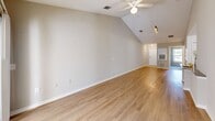 Located at 101 Brookhaven Ct N in Palm Coast, Florida, this single-story, 2-bedroom, 2-bathroom home offers a well-designed open-concept layout ideal for comfortable everyday living. The combined dining and living area is expansive, featuring vaulted ceilings, a ceiling fan, and hardwood-style flooring that extends throughout the main living spaces. Sliding glass doors at the rear flood the area with natural light and lead out to a private patio. The kitchen is thoughtfully positioned adjacent to the living area and features warm honey-toned cabinetry, granite-style countertops, stainless steel appliances, and a peninsula with a built-in sink — perfect for casual dining or meal prep. A pantry provides additional storage. Both bedrooms are carpeted and include ceiling fans and closets. The primary bedroom benefits from vaulted ceilings, while the second bedroom features dual windows that invite ample natural light and outdoor views. Each bathroom is finished with tile flooring and warm wood vanities with generous counter space. One bathroom includes a tub-shower combination. Additional conveniences include an in-unit laundry area and an entrance foyer. The home's neutral color palette and clean finishes create a bright, welcoming atmosphere throughout.