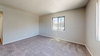 Located at 6200 S Campbell Ave in Tucson, AZ, this single-floor unit offers three bedrooms, one bathroom, and a practical, well-organized layout. The combined kitchen and living room serves as the heart of the home, featuring warm wood-toned cabinetry, dark countertops, and white appliances including a range and refrigerator. A peninsula counter separates the kitchen from the living area, creating a functional open-concept feel. The living room is finished with plush carpeting and opens to a private outdoor balcony through a sliding glass door, letting in natural light and views of surrounding greenery. Each of the three bedrooms is carpeted and finished with neutral walls and textured ceilings, providing a clean and versatile canvas. The primary bedroom includes access to a closet, while at least one additional bedroom features a dedicated closet as well. A connecting hallway links the bedrooms and common areas. The full bathroom is outfitted with a tiled shower-tub combination, wood-look flooring, and clean white fixtures. Throughout the unit, the design is straightforward and functional, with consistent neutral tones, adequate natural light from windows with vertical blinds, and ceiling ventilation throughout.