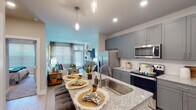 Located on Baymar Drive in Raleigh, NC, this single-floor residence offers a thoughtfully designed layout that balances modern finishes with everyday functionality. The open-concept kitchen is a standout feature, showcasing gray shaker-style cabinetry, granite countertops, stainless steel appliances, and a central island with a built-in sink and pendant lighting overhead. Light wood-style flooring runs throughout the main living areas, lending warmth and continuity to the space. A dedicated pantry adds practical storage just steps from the kitchen. The living room is bright and welcoming, with large windows dressed in horizontal blinds that allow for ample natural light. A glass-paneled exterior door opens from the living area, enhancing the sense of openness. The bedroom continues the light-filled aesthetic with a generously sized window, plush carpet, and a ceiling fan for year-round comfort. The bathroom features a sleek, frameless sliding glass shower enclosure with marble-style tile surround, granite vanity top, and wood-look flooring, offering a clean and contemporary feel. Throughout the residence, neutral tones, recessed lighting, and consistent finishes create a cohesive and inviting atmosphere well-suited for comfortable everyday living.