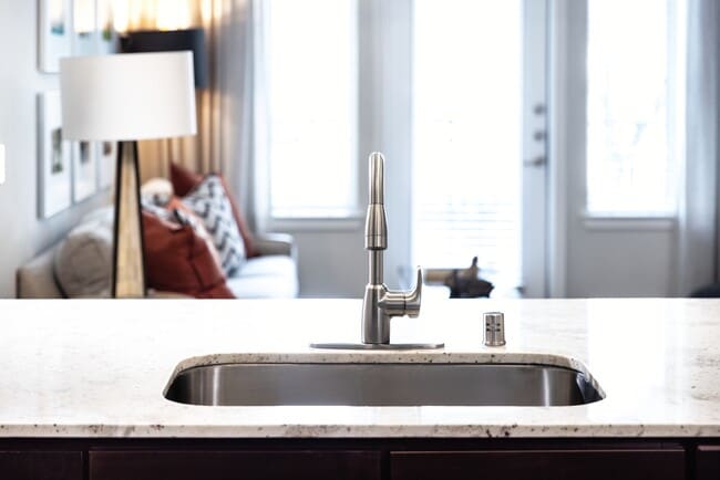 Cocina con gabinetes de roble, encimeras de granito, placa para salpicaduras de azulejos y electrodomésticos de acero inoxidable. - Avalon Lakeside